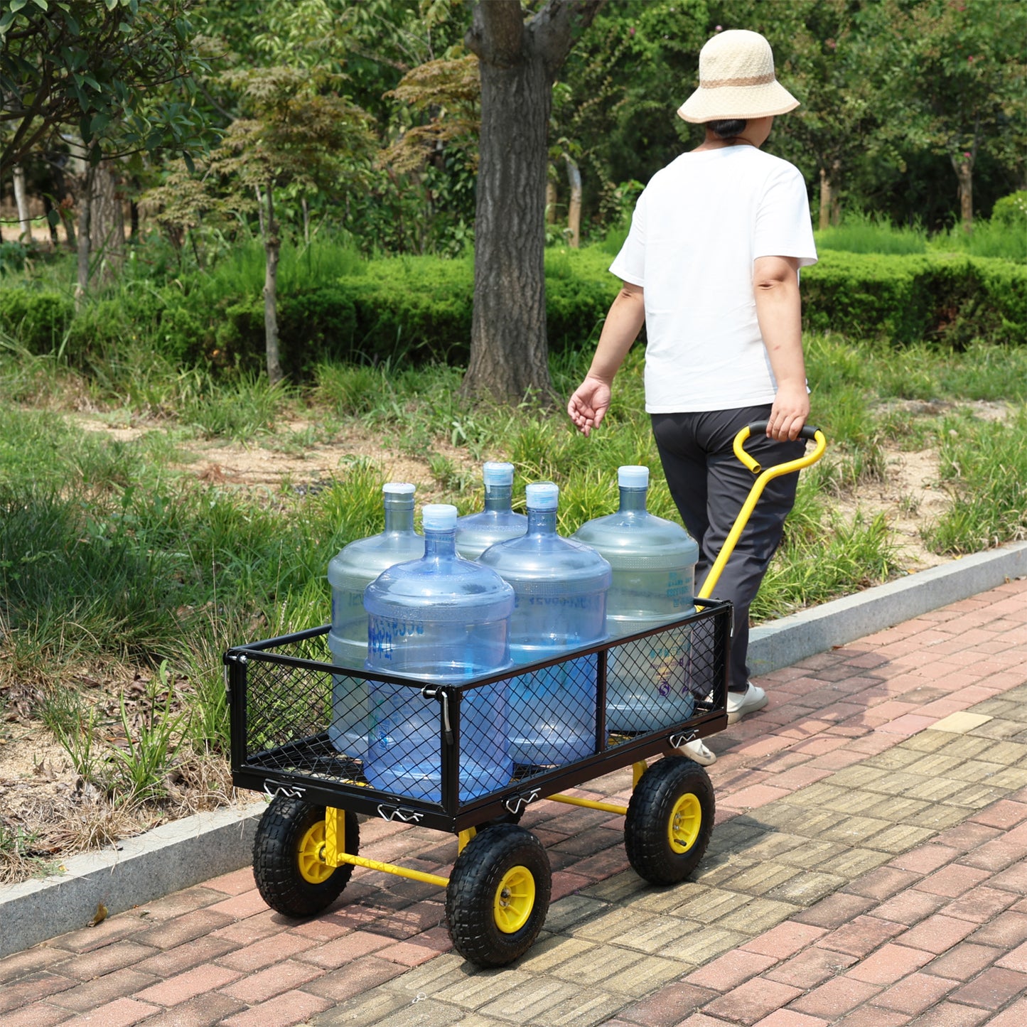 Black mesh utility cart with yellow frame carrying five large water jugs on a brick pathway