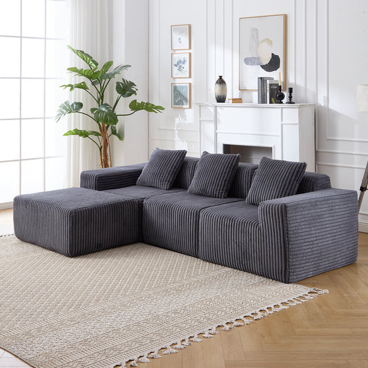 Dark gray corduroy sectional sofa with plush cushions and an ottoman modern living room furniture