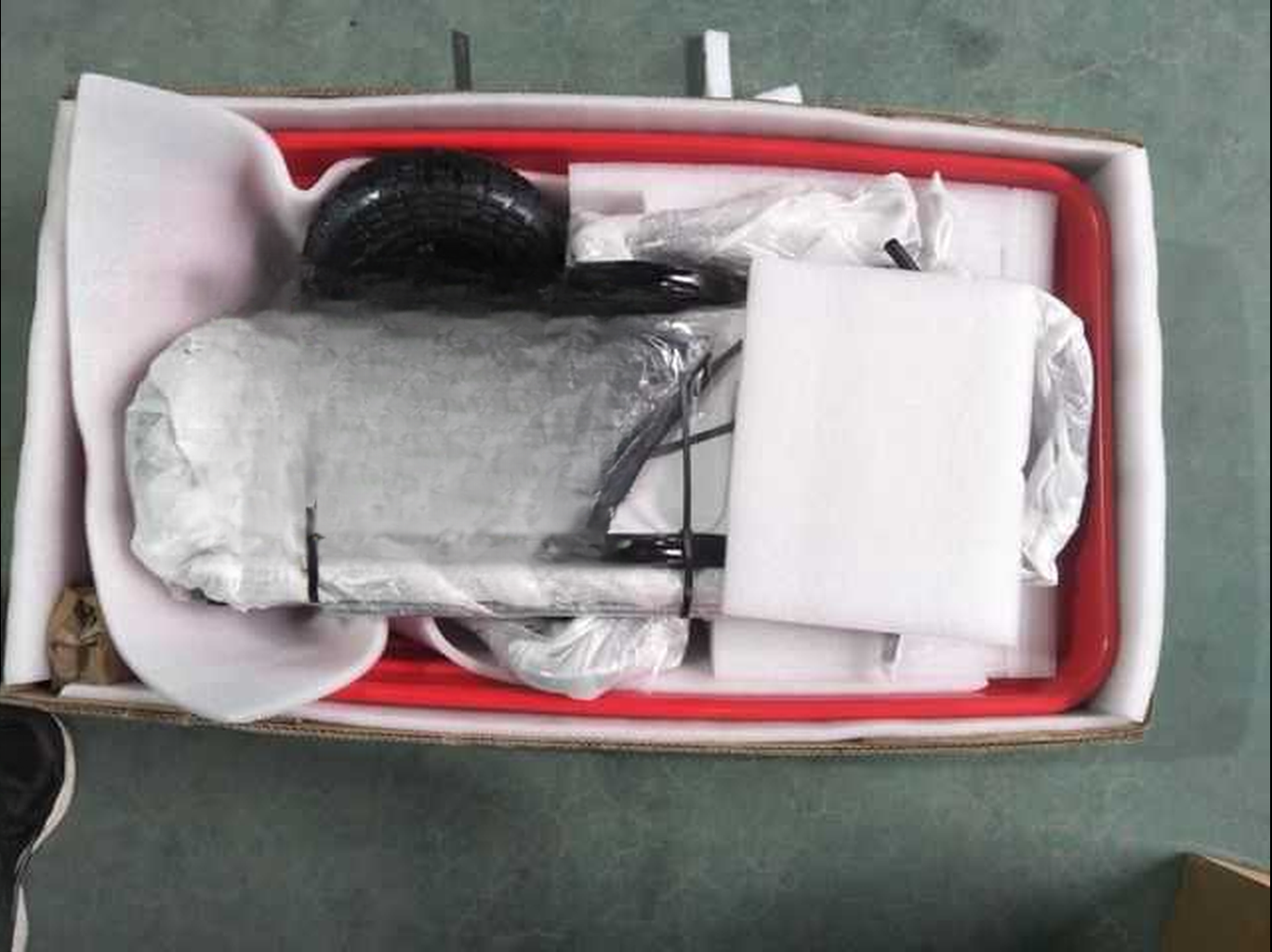 Red frame utility cart components in protective packaging inside box
