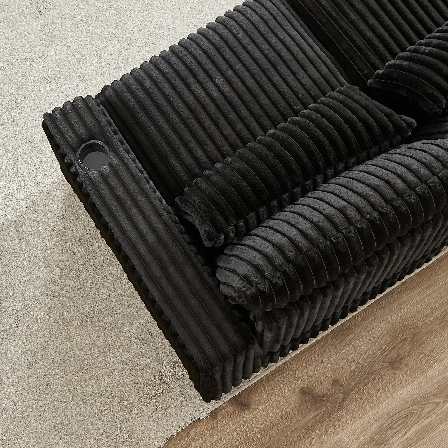 Plush black corduroy sofa section with integrated cup holder designed for ultimate relaxation