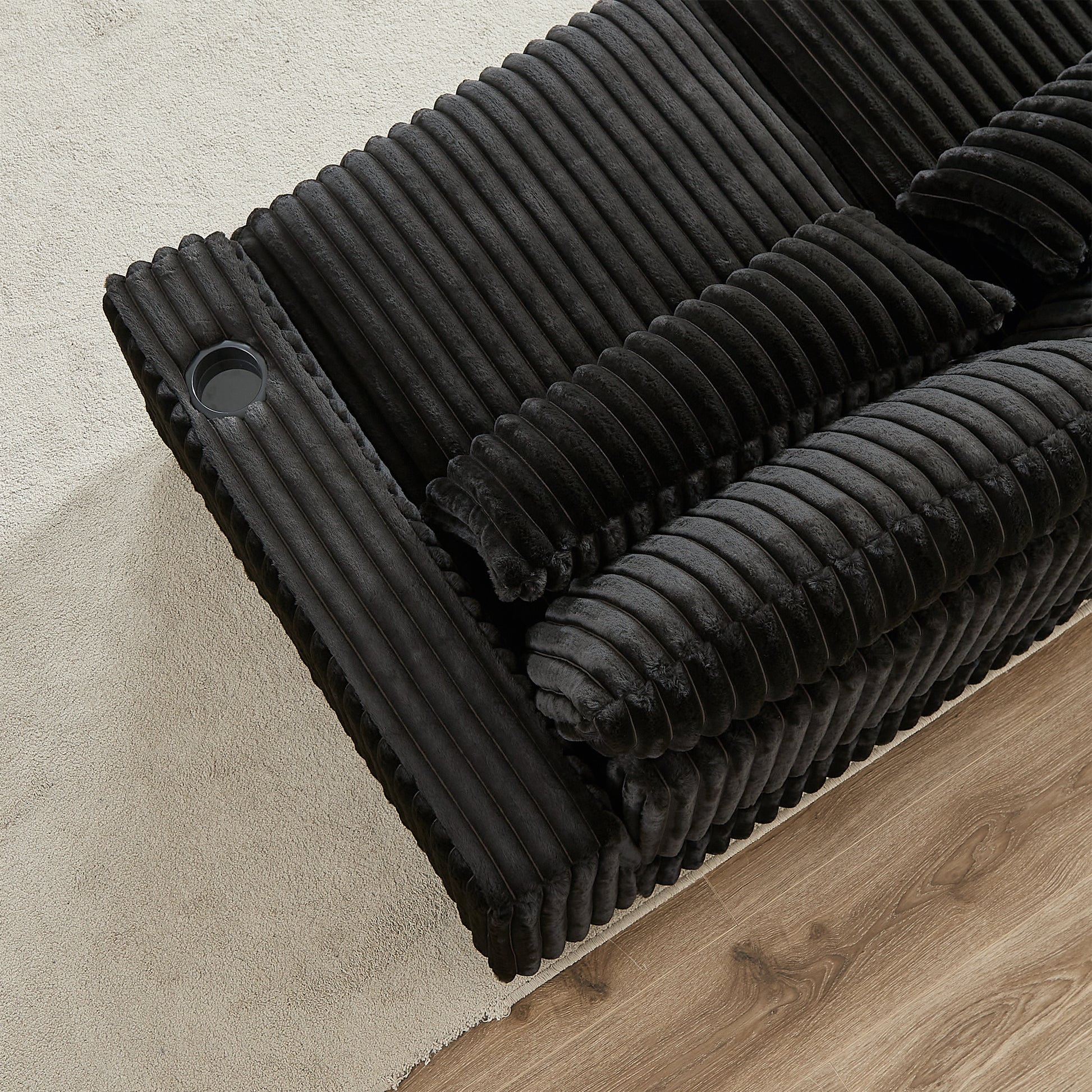 Plush black corduroy sofa section with integrated cup holder designed for ultimate relaxation