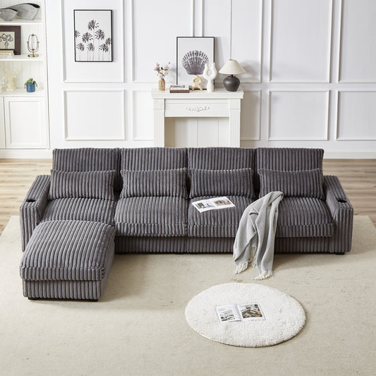 Plush corduroy sectional sofa in charcoal gray with multiple throw pillows and an ottoman