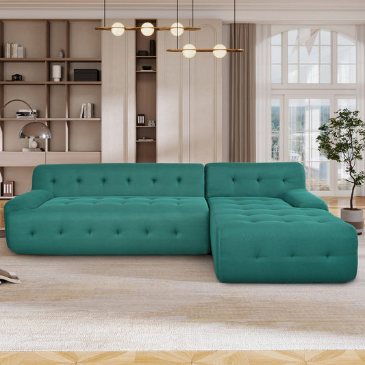 Teal fabric sectional sofa with tufted cushions and a chaise lounge