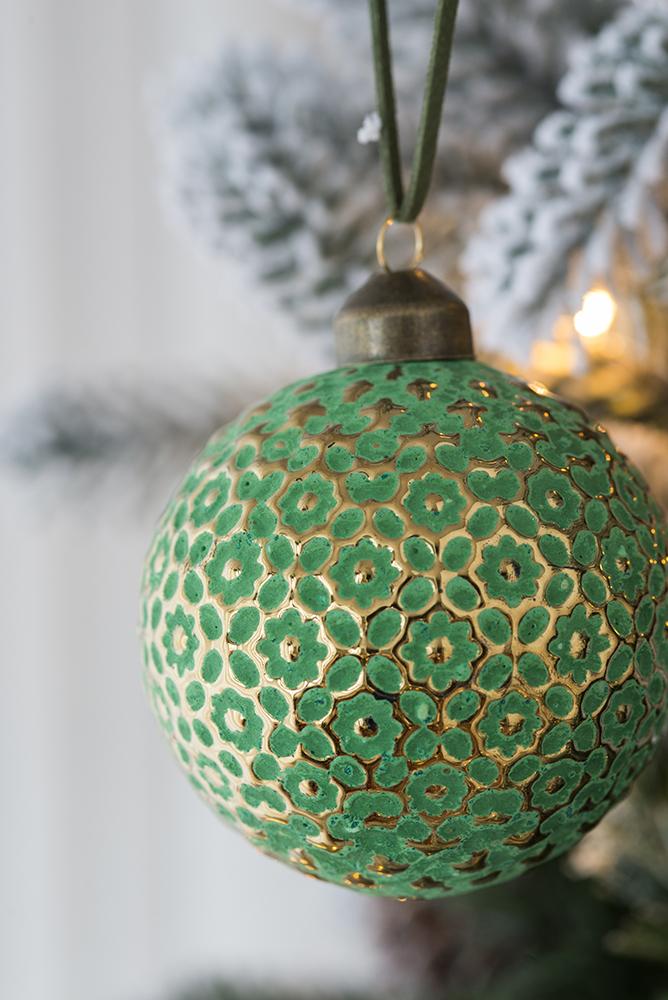 Emerald green glass Christmas ornament with intricate gold floral pattern hanging detail