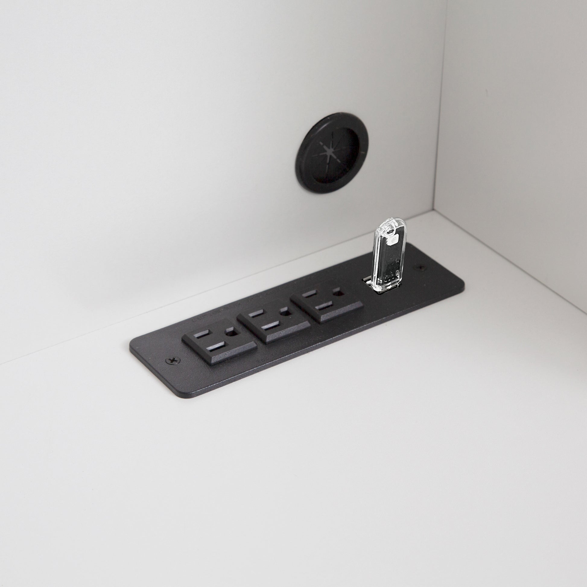 Black underdesk power strip with three outlets and a clear cord protector