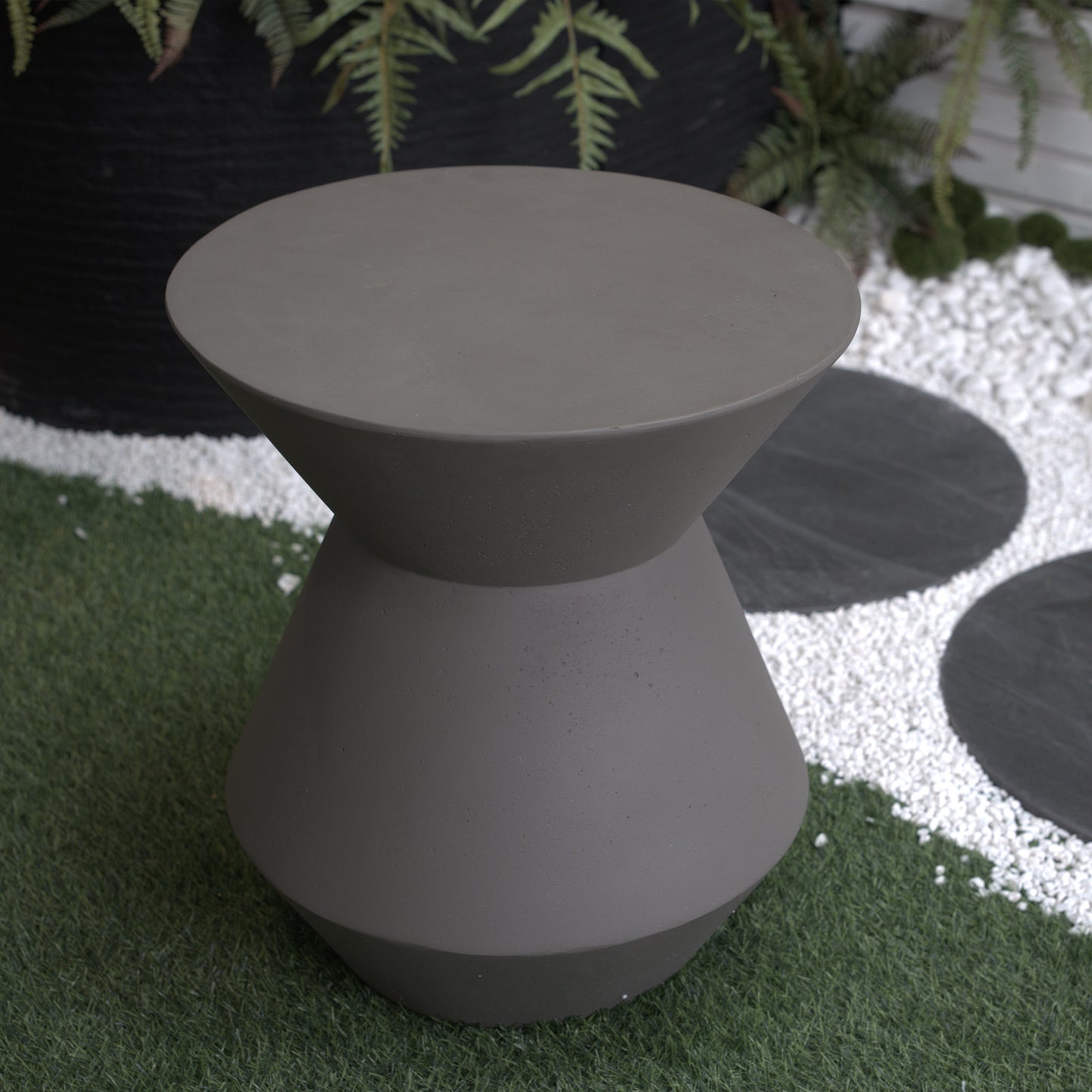 Modern hourglass garden stool in a matte grey concrete finish