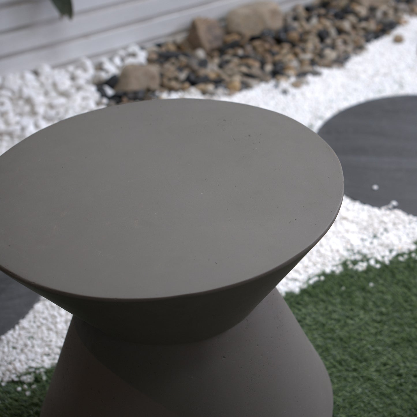 Modern grey concrete outdoor side table with a smooth rounded top