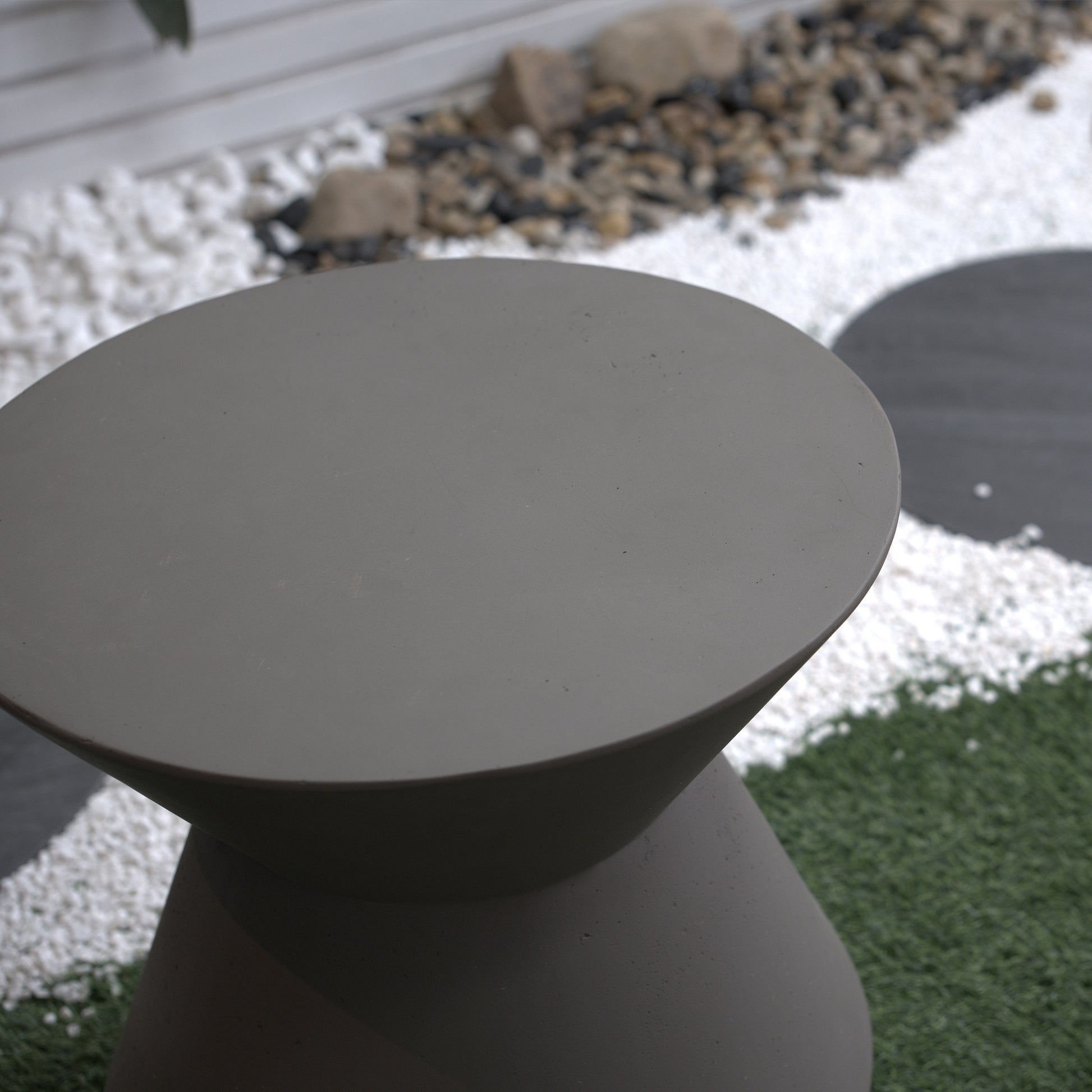 Modern grey concrete outdoor side table with a smooth rounded top