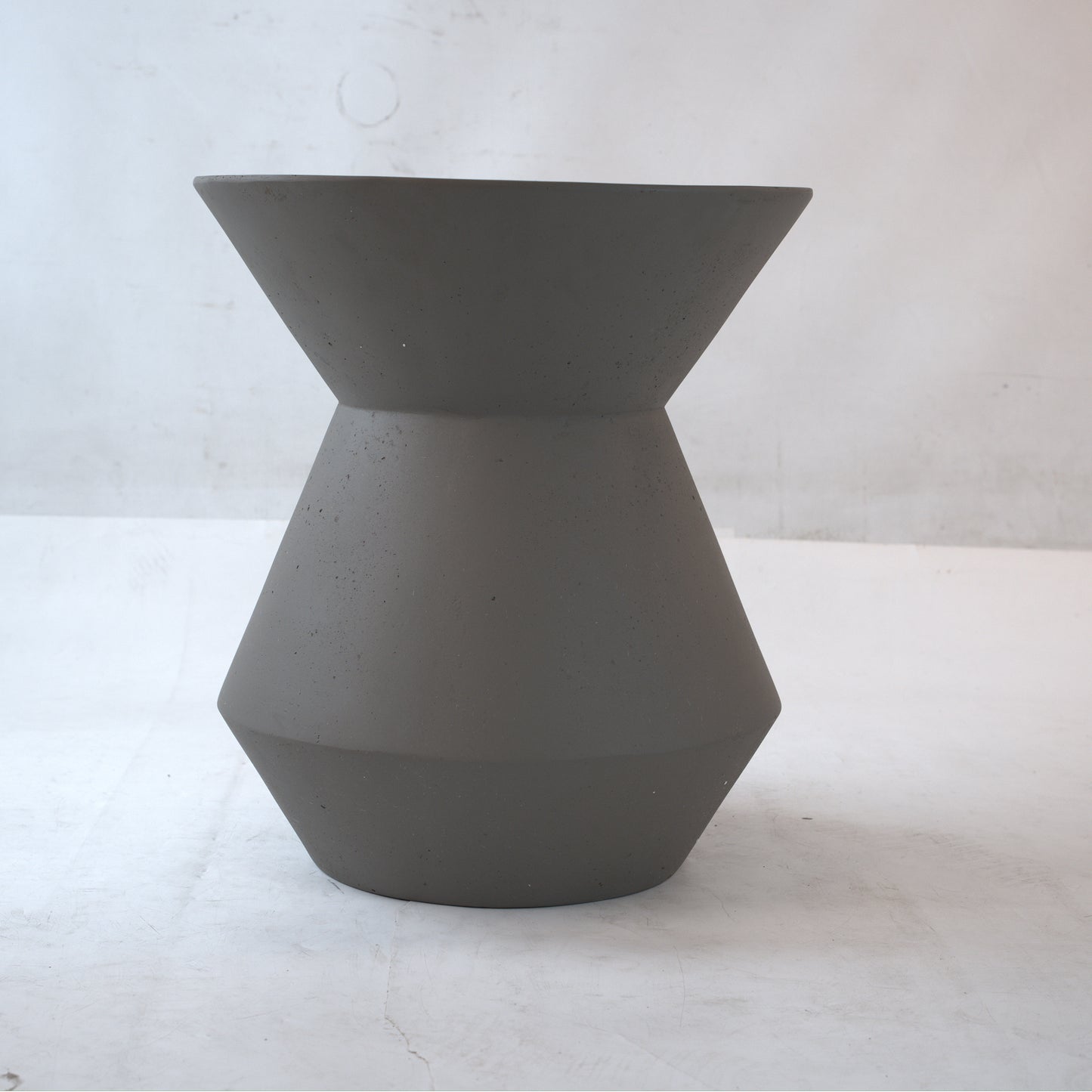 Modern hourglass cement stool with geometric design perfect for minimalist decor