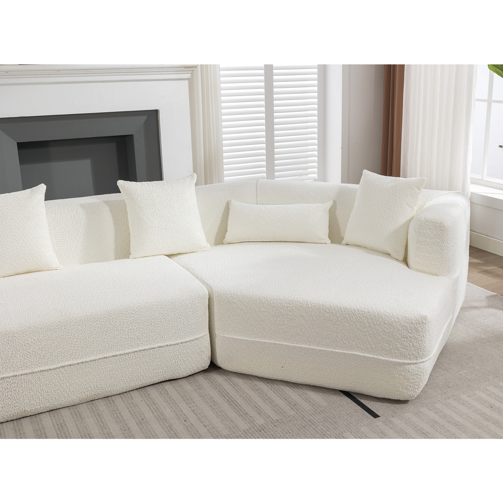 Plush ivory boucle sectional sofa with textured fabric and four accent pillows