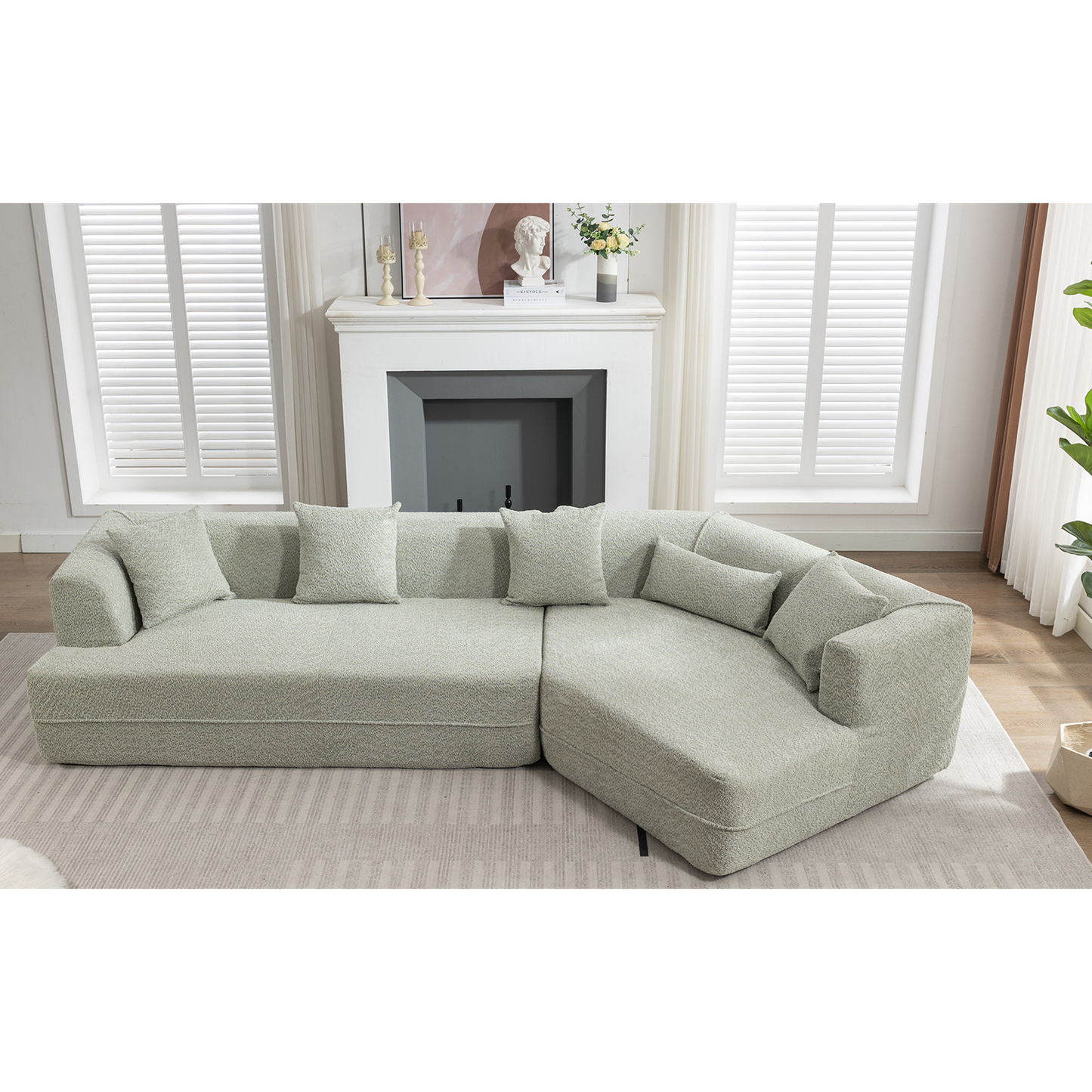 Pale green textured fabric sectional sofa with plush cushions in a modern living room