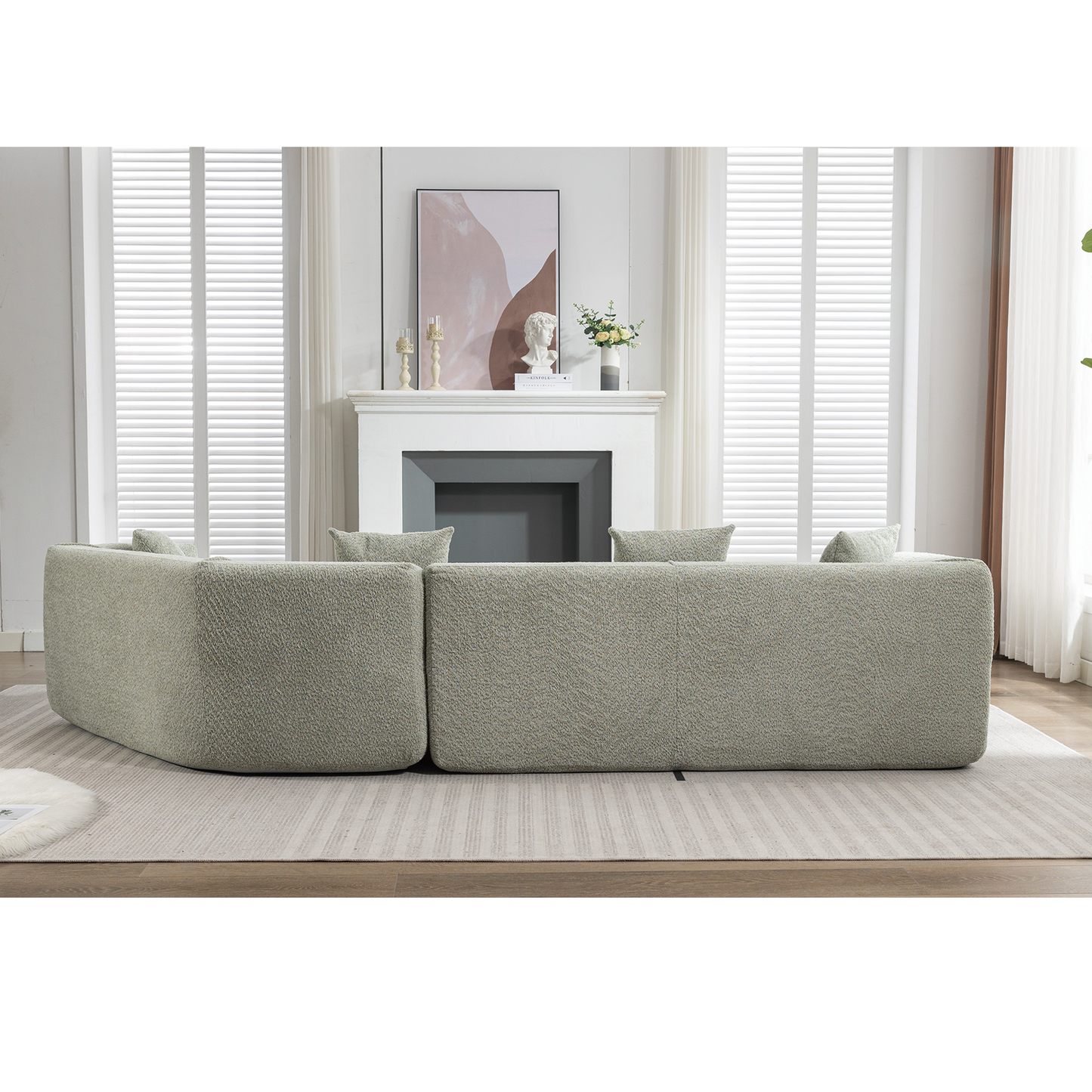 Curved sectional sofa in a textured light green boucle fabric perfect for modern living rooms