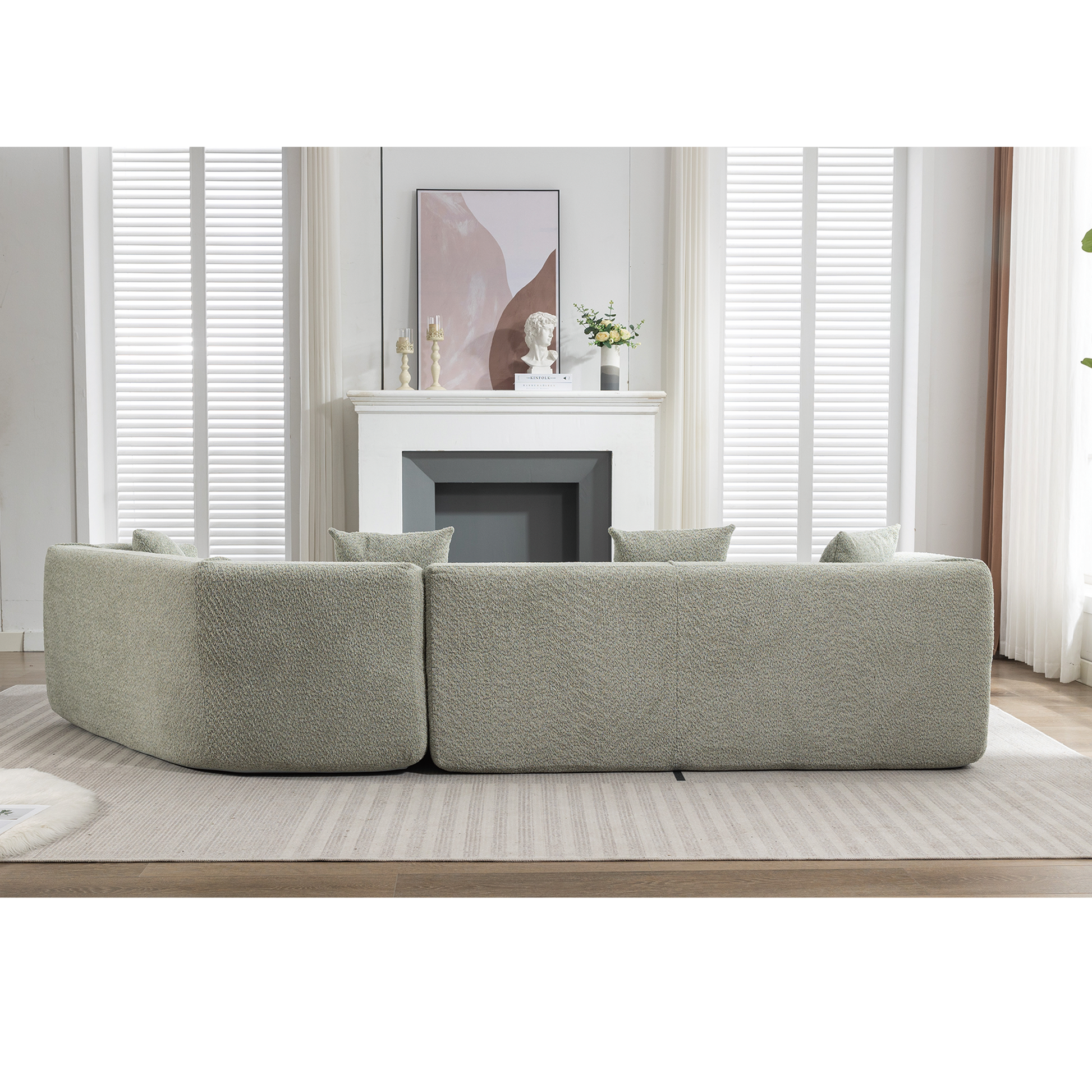 Curved sectional sofa in a textured light green boucle fabric perfect for modern living rooms