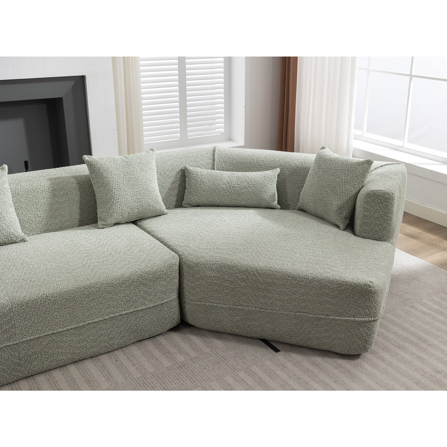 Sage green boucle fabric sectional sofa with plush throw pillows