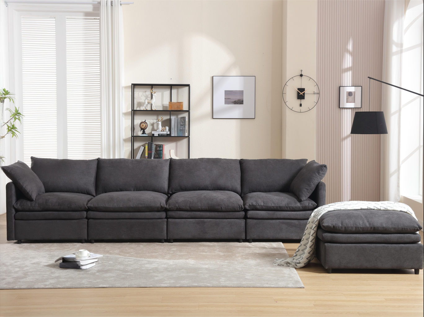 Dark gray fabric sectional sofa with plush cushions and a matching ottoman