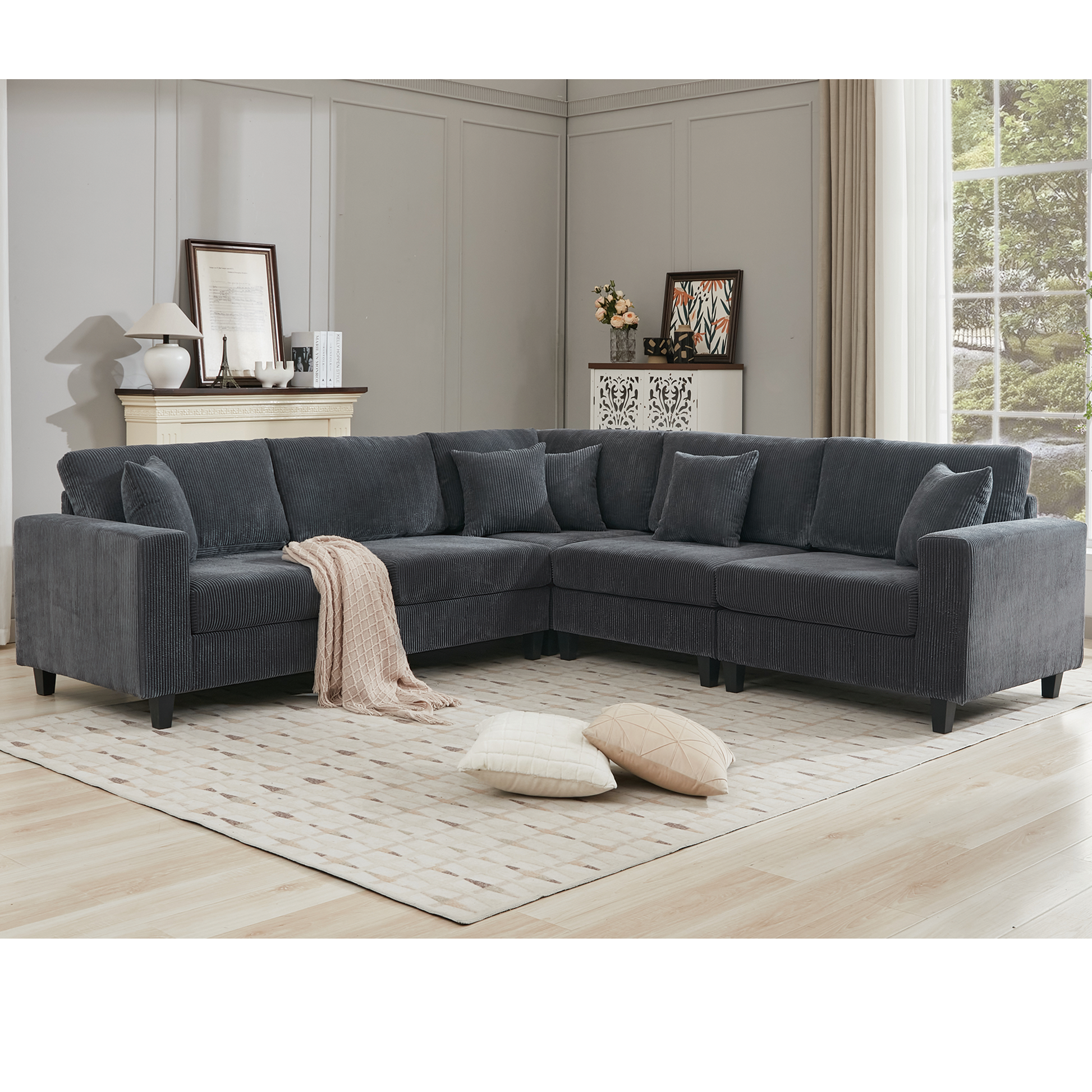 Dark gray corduroy sectional sofa with plush cushions and a knitted throw blanket