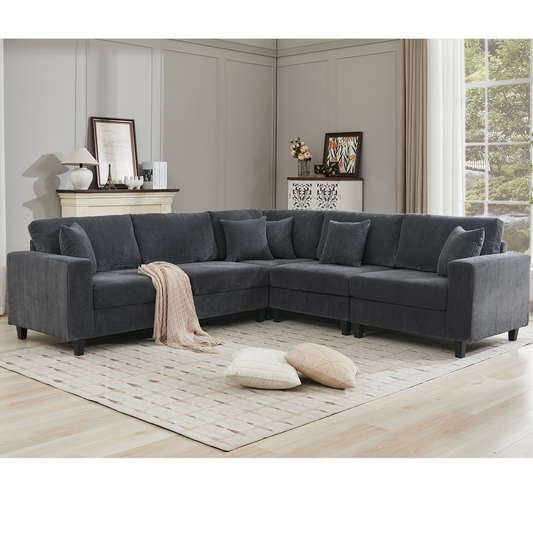 Dark gray corduroy sectional sofa with plush cushions and a knitted throw blanket