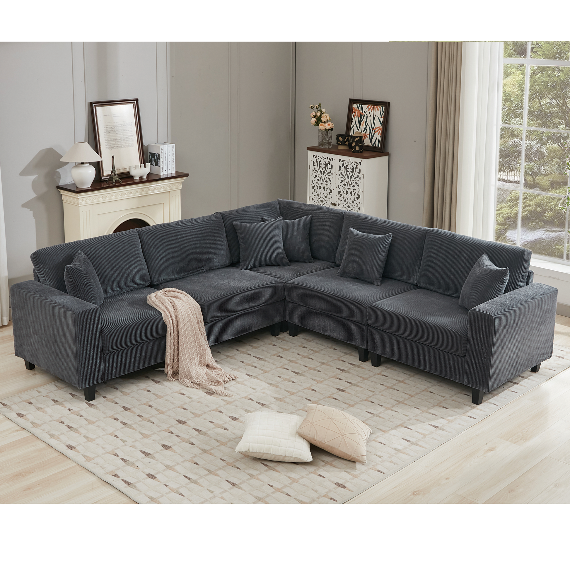 Deep charcoal grey corduroy sectional sofa with plush cushions and throw blanket
