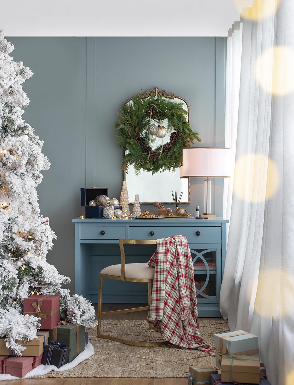 Flocked artificial Christmas tree with warm white lights and festive gifts