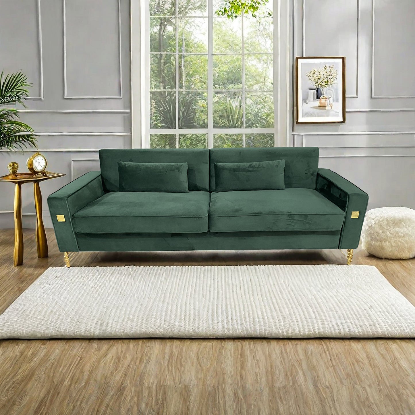 Emerald green velvet sofa with gold accents and two matching throw pillows