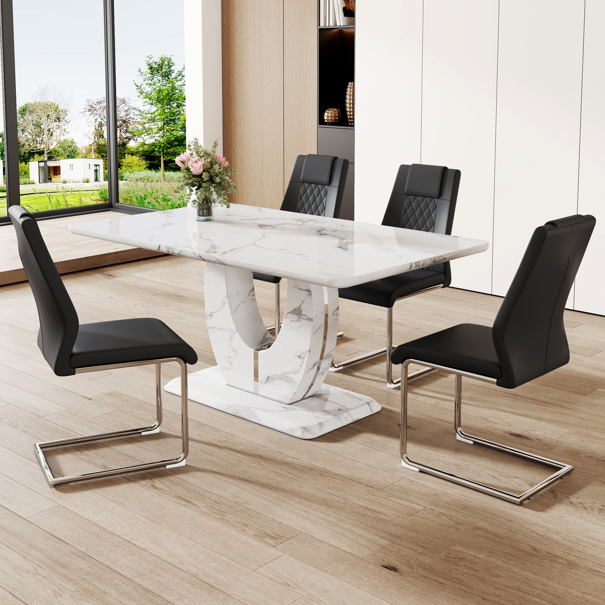 Modern marble dining table with white pedestal base and four black faux leather chairs