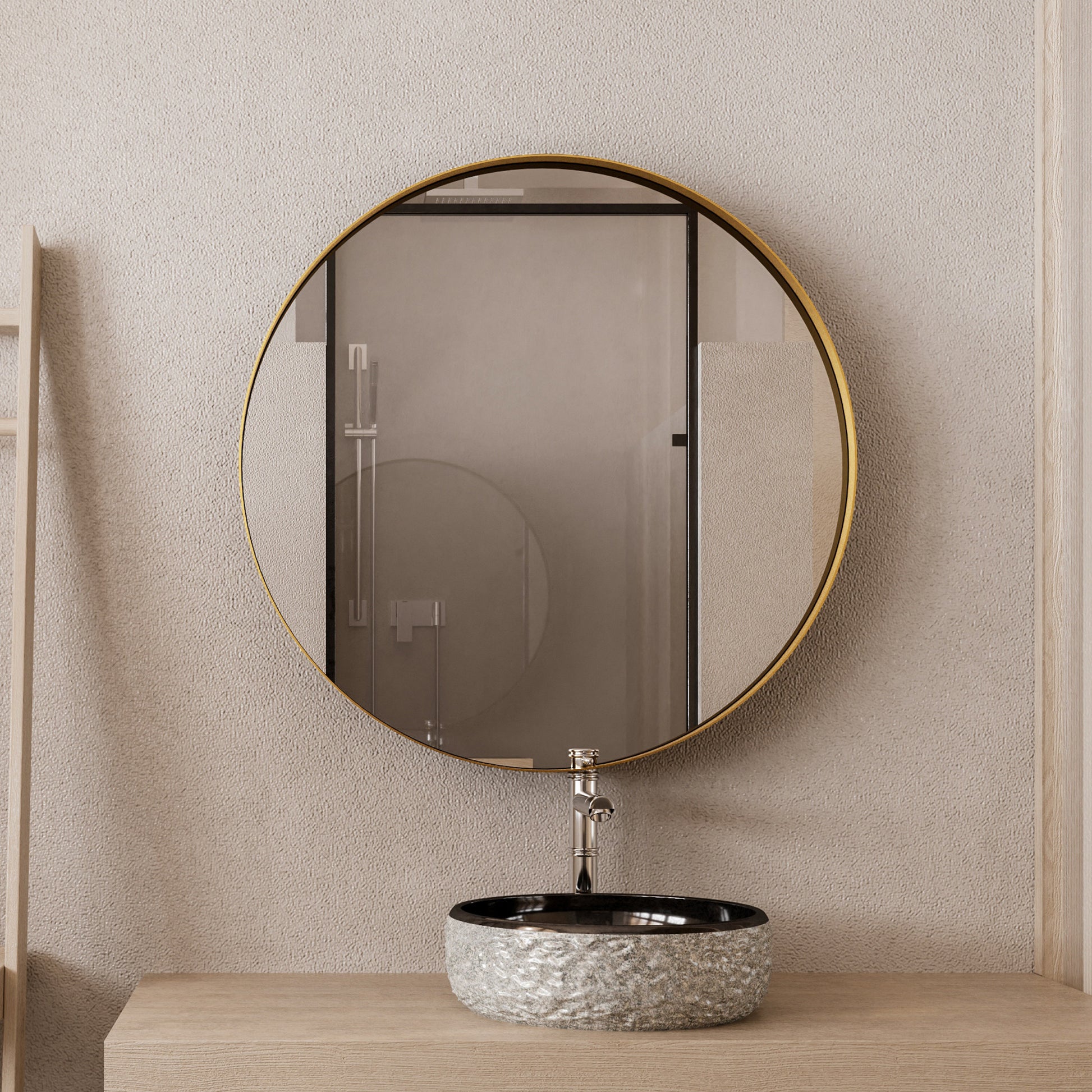 Round brassframed mirror above a textured grey vessel sink and chrome faucet