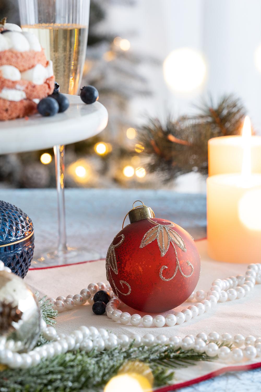 Red glass Christmas ornament with gold leaf detail part of holiday decor