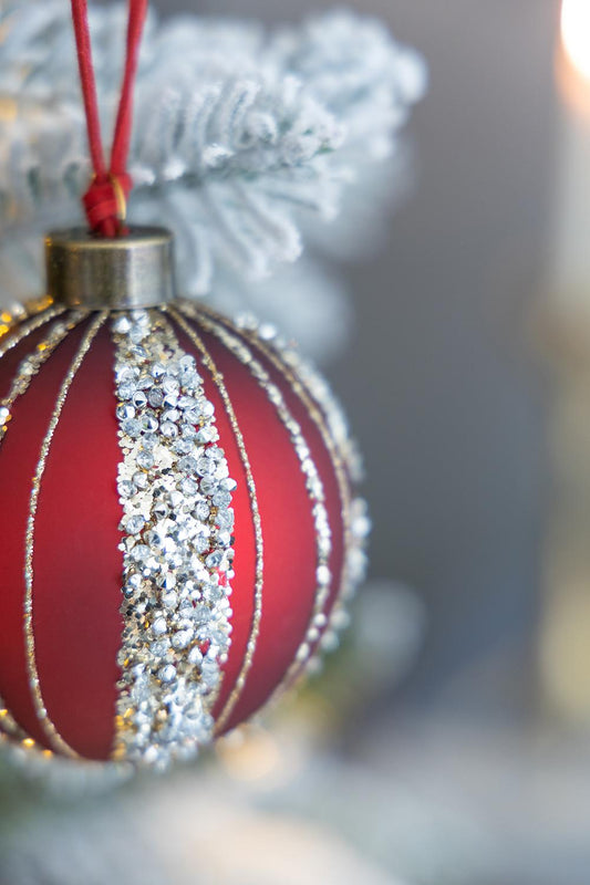 Red glass Christmas ornament with silver glitter stripes and rhinestone accents
