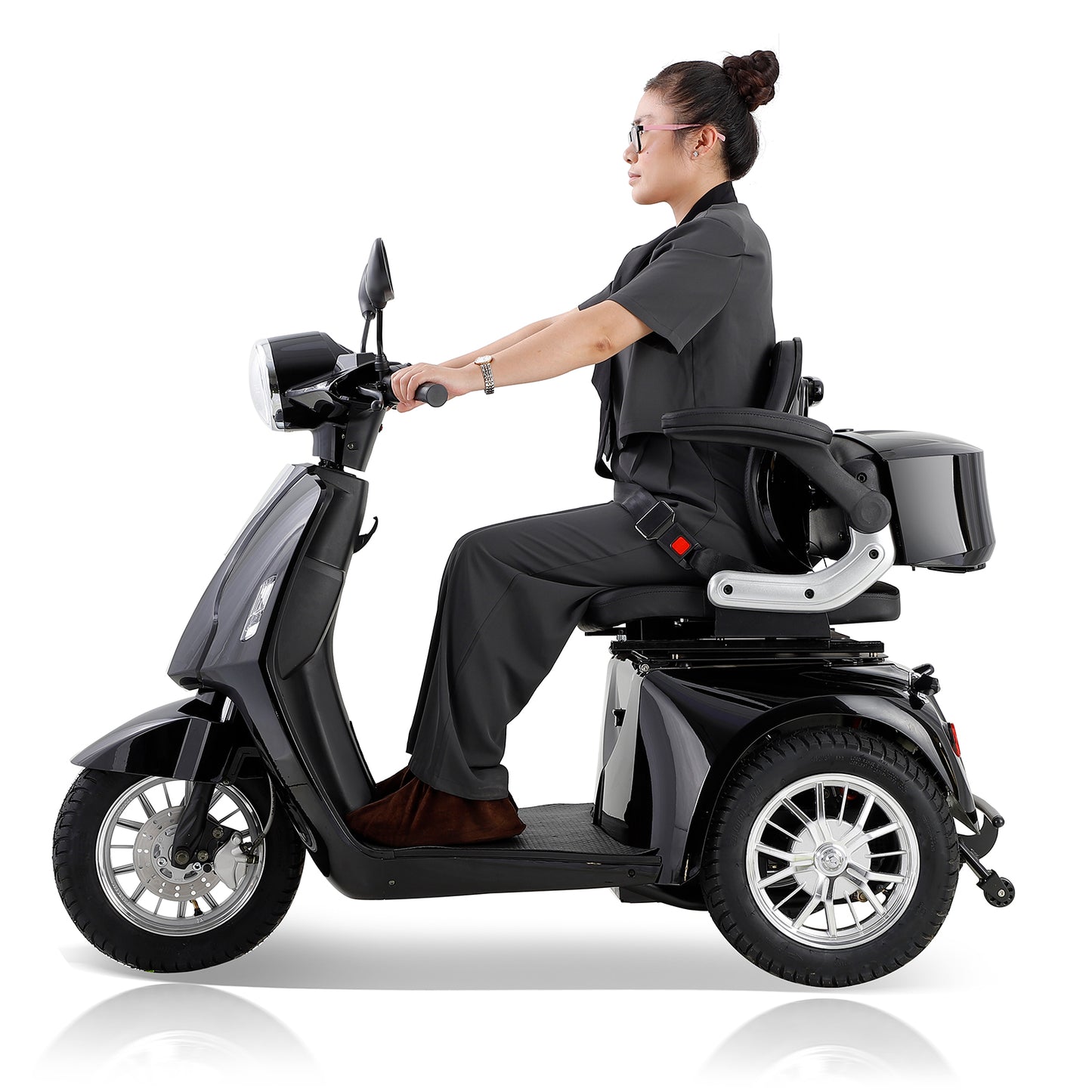 Black threewheel mobility scooter with a woman rider in business attire