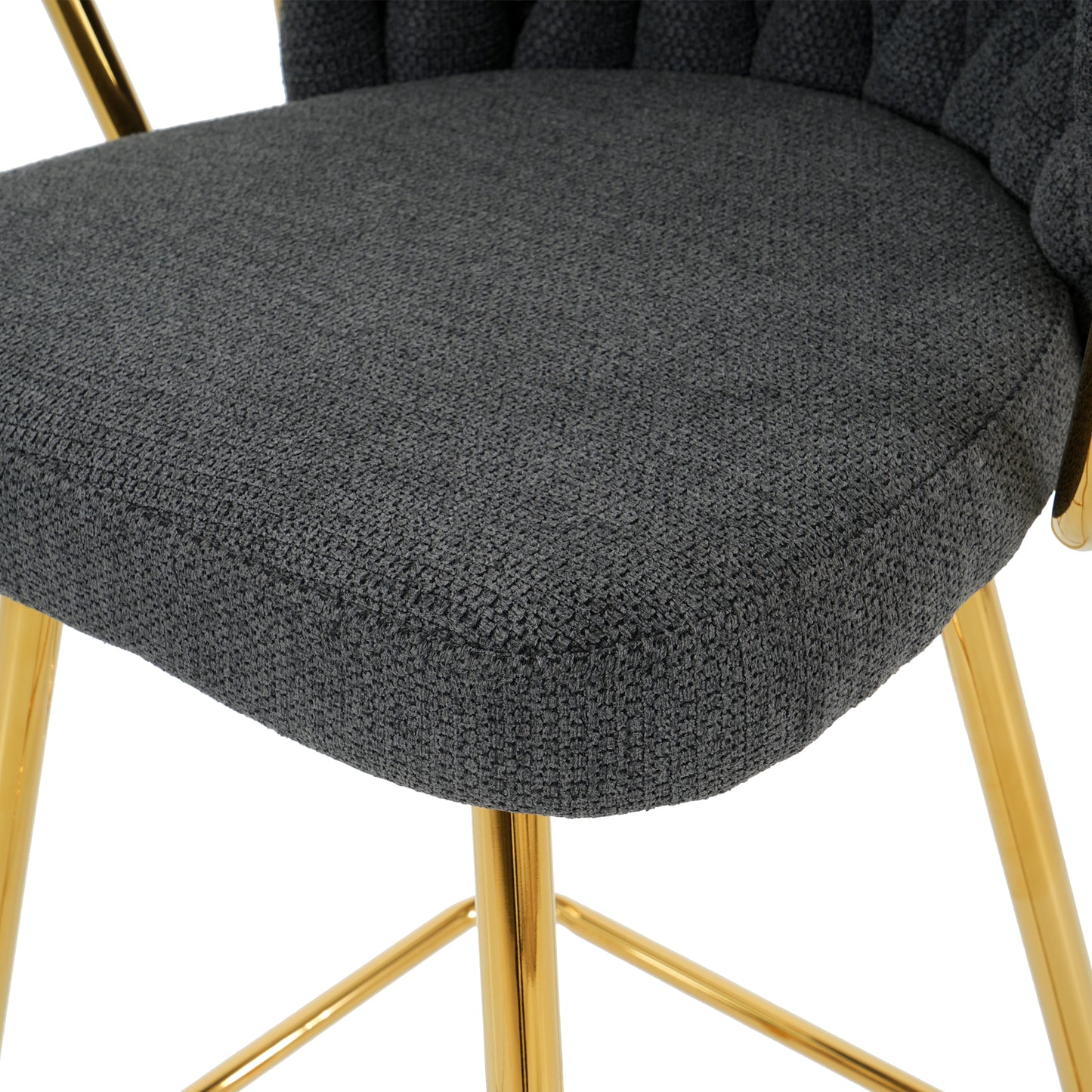 Close up of a plush dark grey fabric seat with tufted details and shiny gold legs