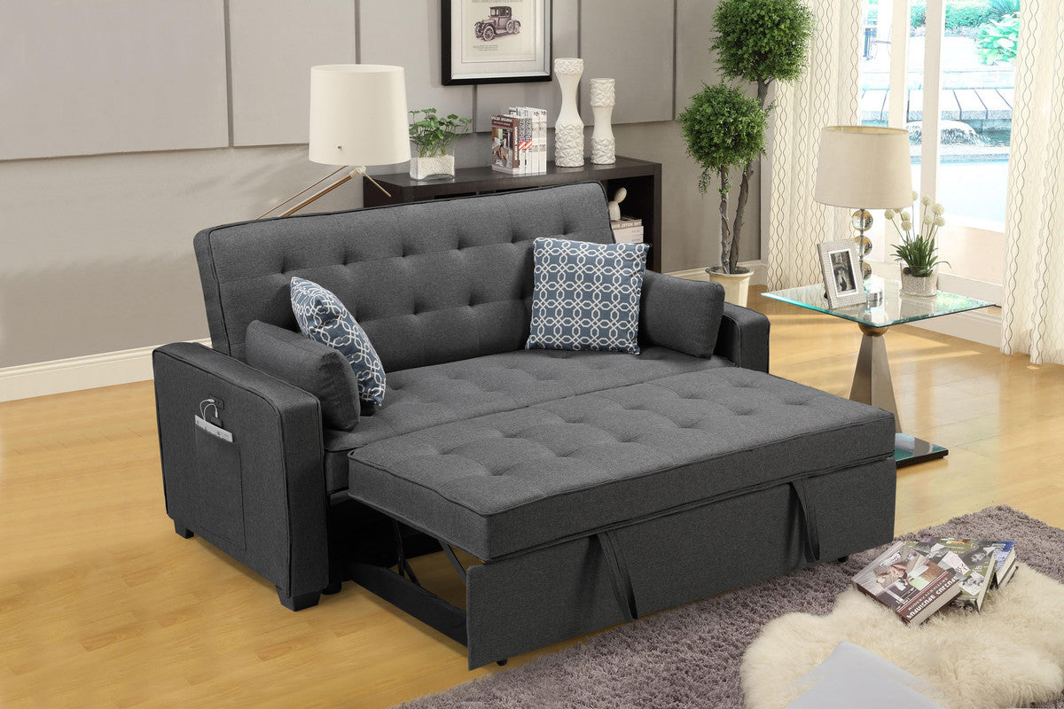 Dark gray tufted futon sofa with pullout bed extension and patterned accent pillows for living room