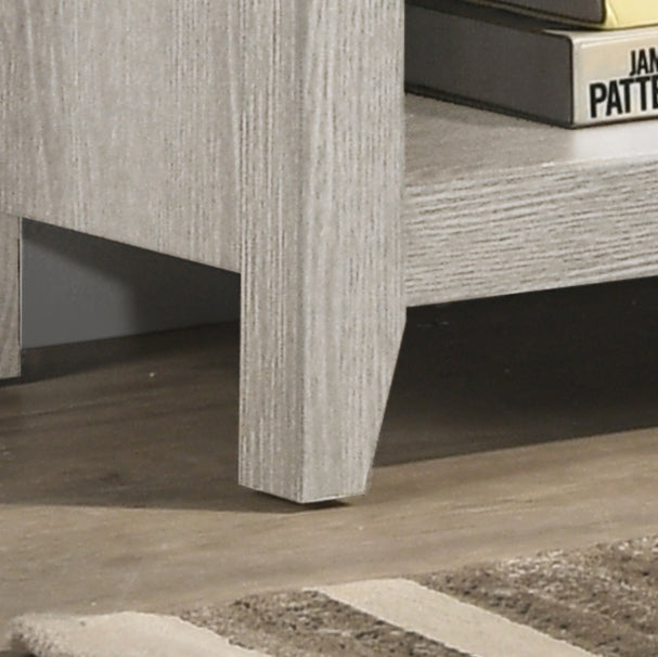 Closeup of a light gray wood grain textured furniture leg and shelf with books