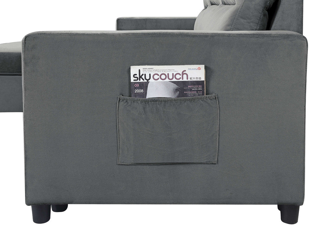 Dark grey velvet sofa with side pocket holding a magazine