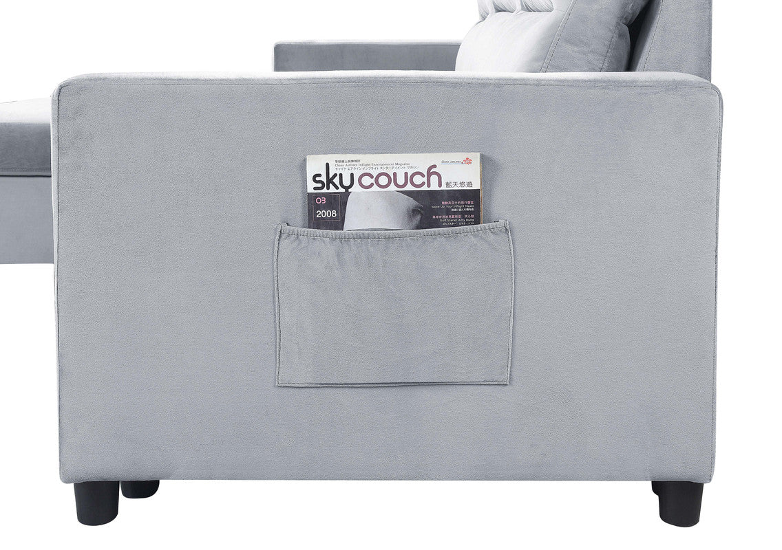 Gray velvet sofa with integrated side pocket holding a magazine