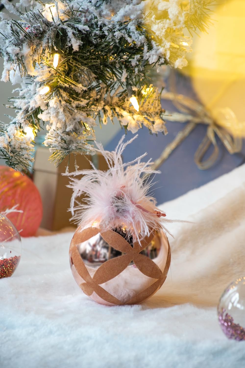 Rose gold Christmas bauble with pink feathers and diamond pattern