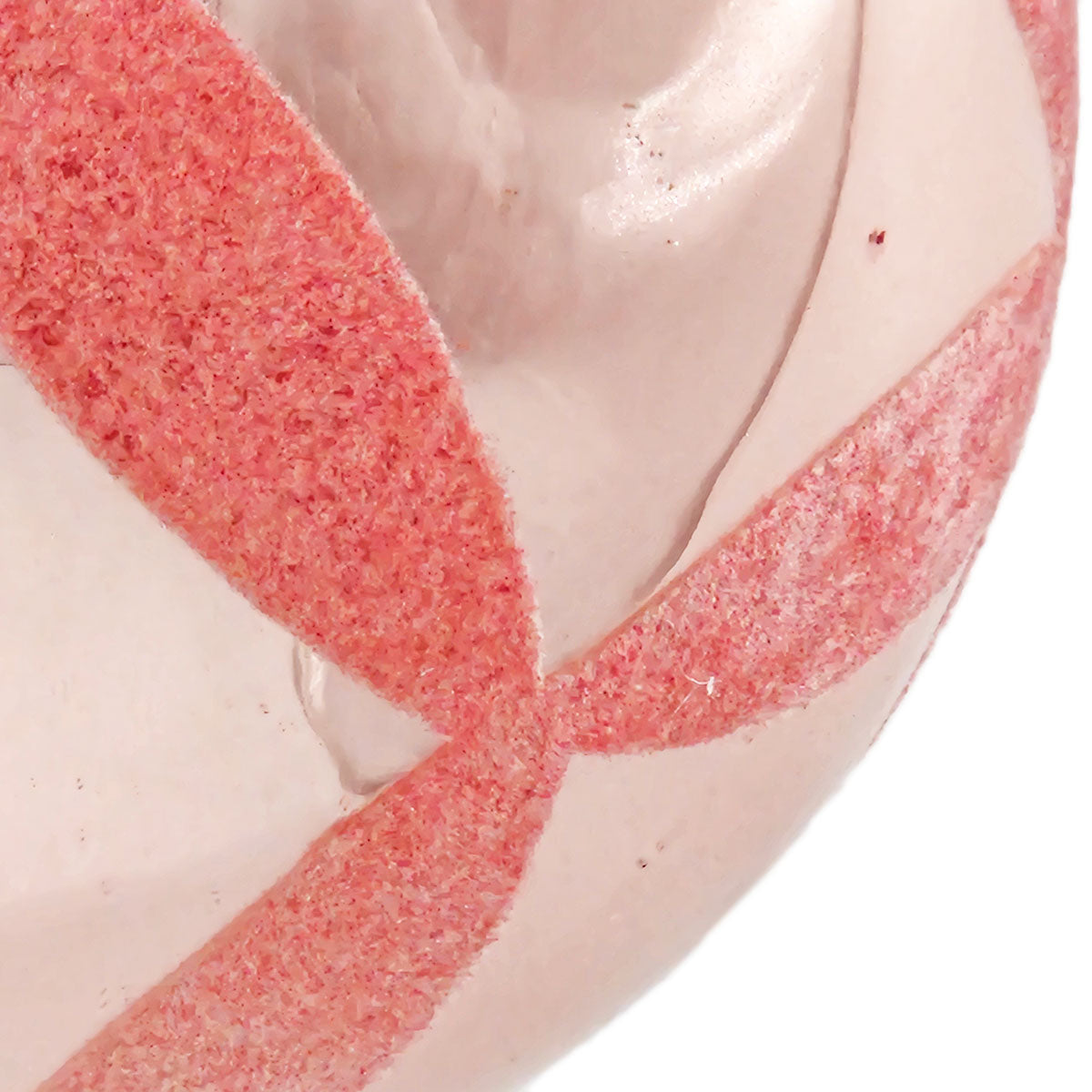Closeup of a pink glitter stripe on a smooth pearlescent white cosmetic puff