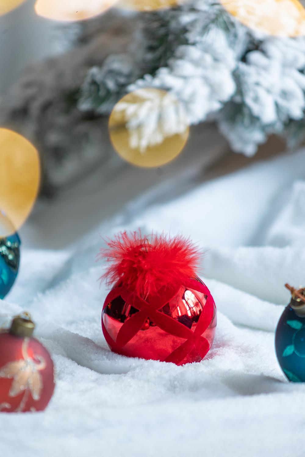 Red glass Christmas ornament with feather topper and silver crisscross design