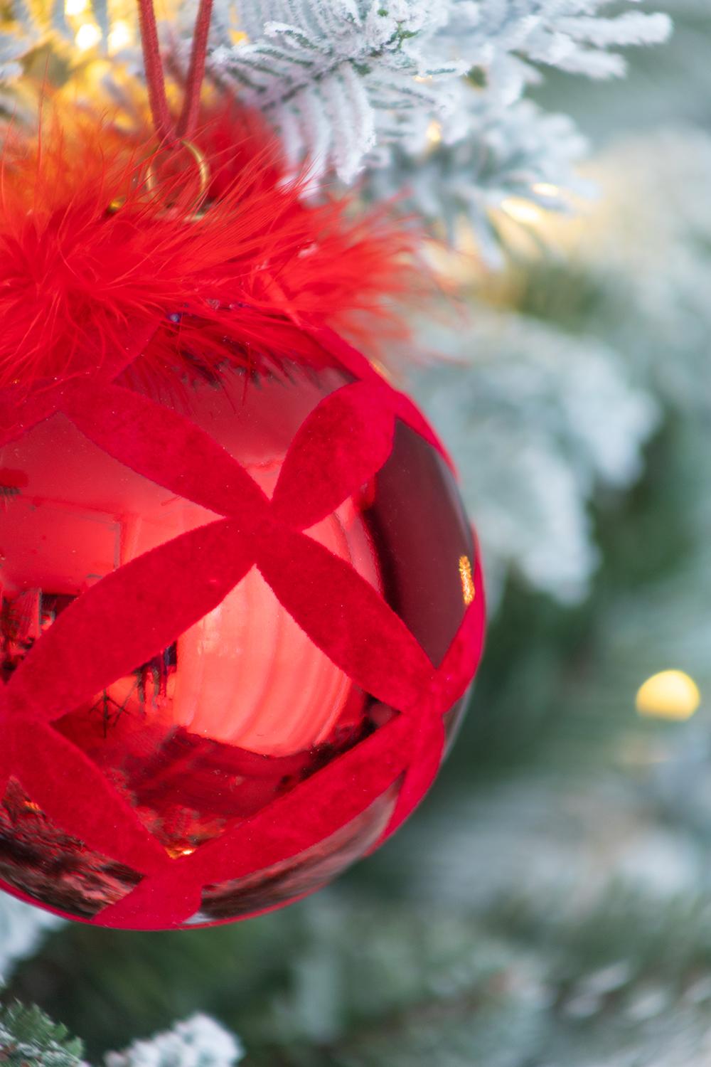 Shiny red glass Christmas bauble with velvet ribbon detail