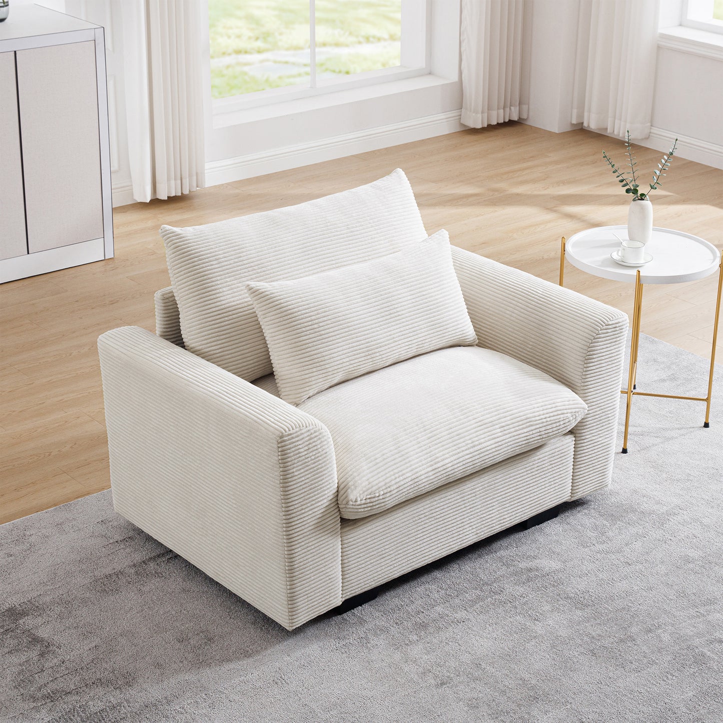 Cream corduroy armchair with plush seat and back cushions and a throw pillow