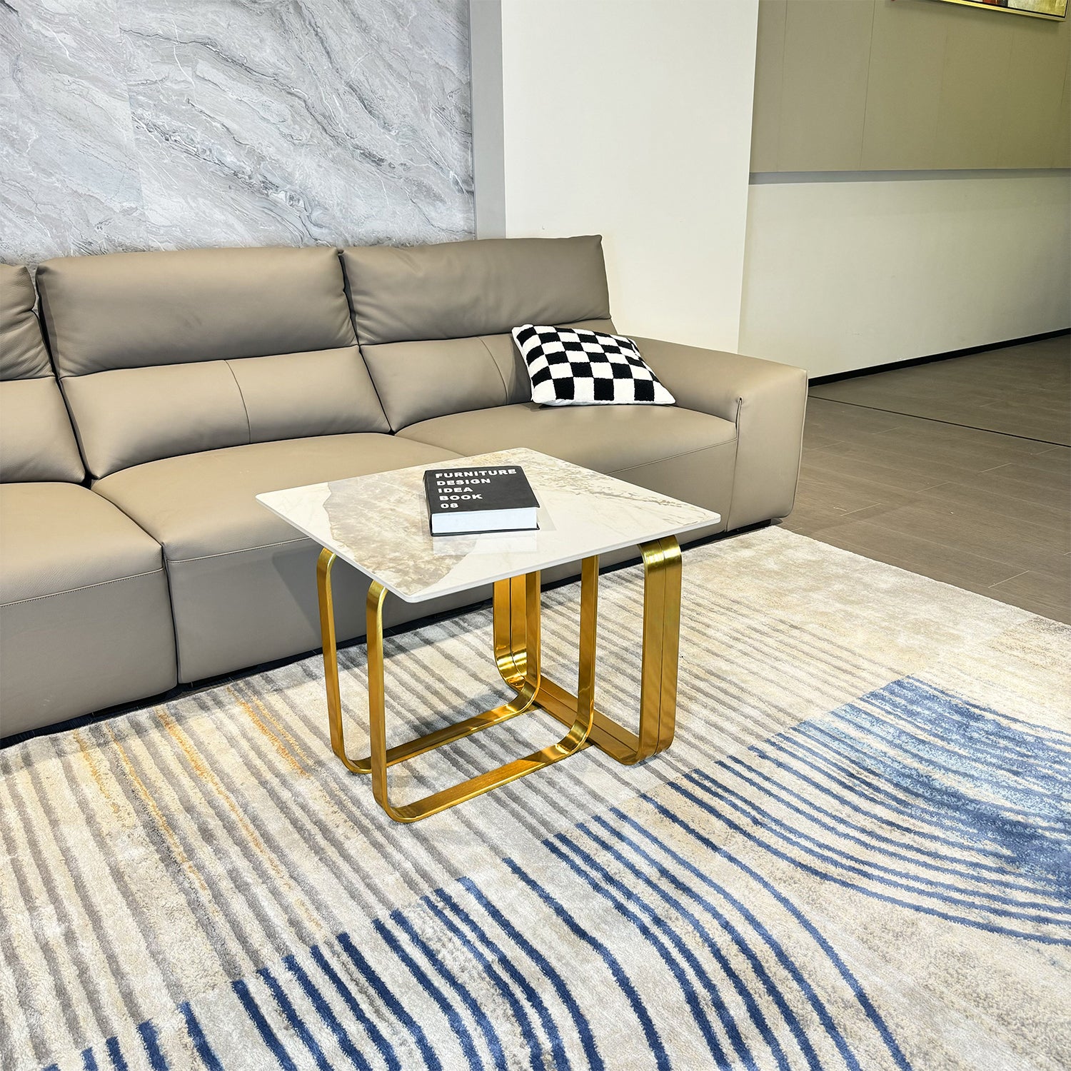 Modern taupe leather sectional sofa with a checkered pillow and side table
