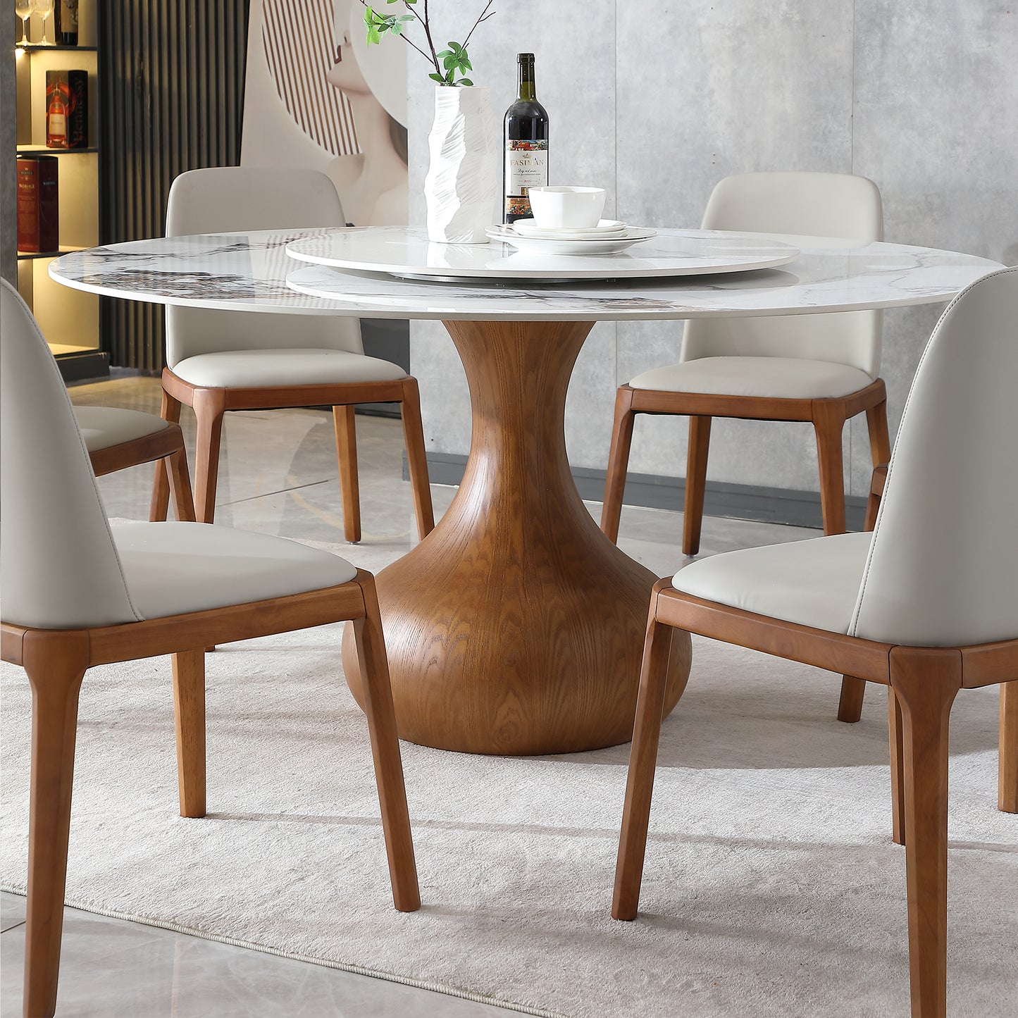Round marble dining table with rotating lazy susan and wooden pedestal base seating four guests