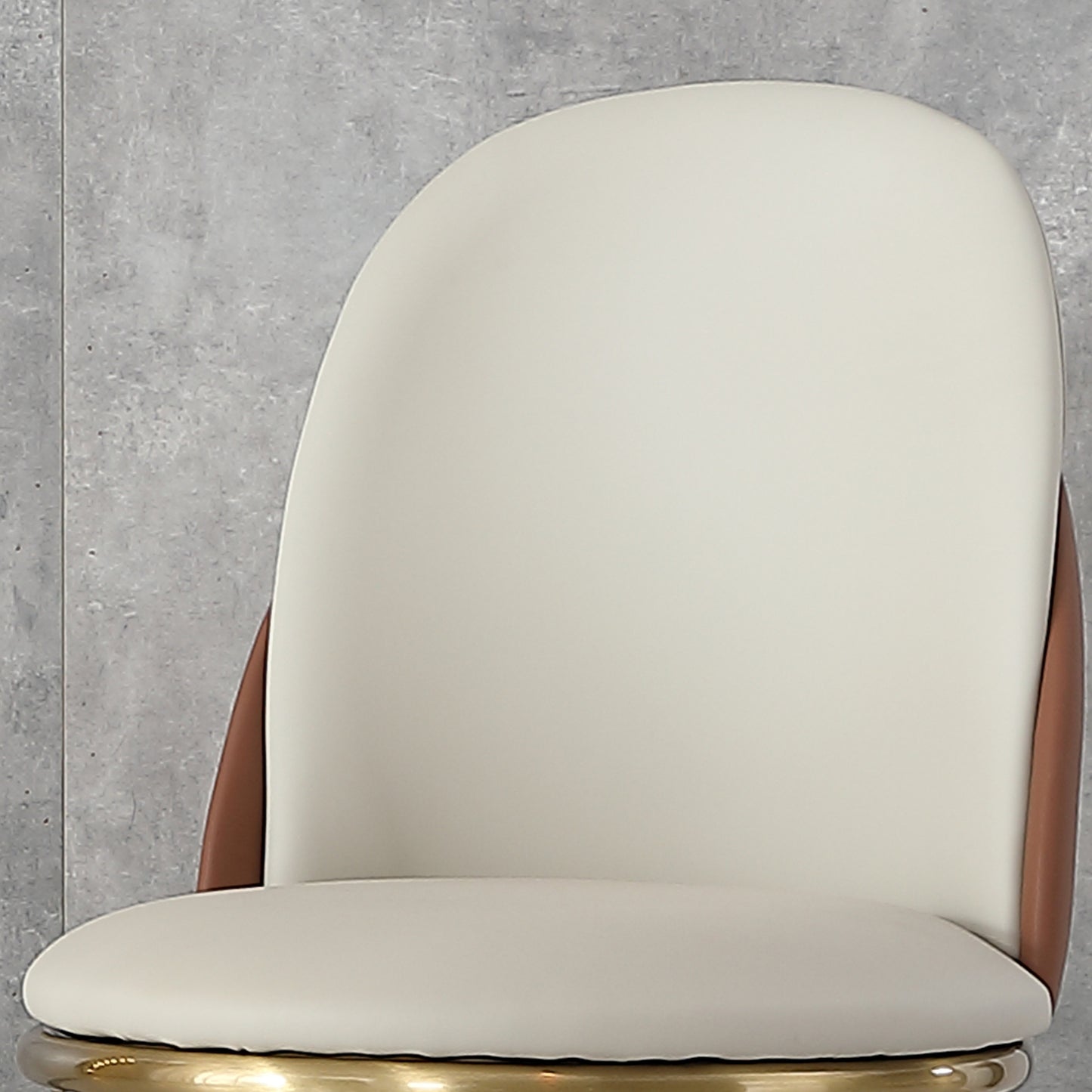 Modern cream faux leather bar stool with rich brown accents and gold base