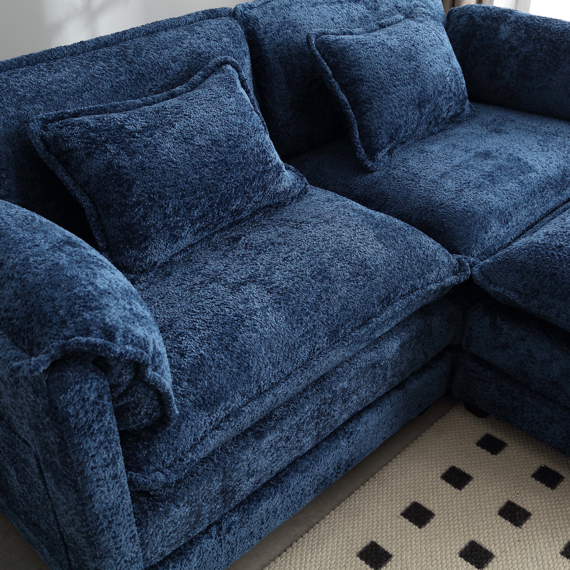 Plush navy blue sectional sofa with textured fabric and matching throw pillows