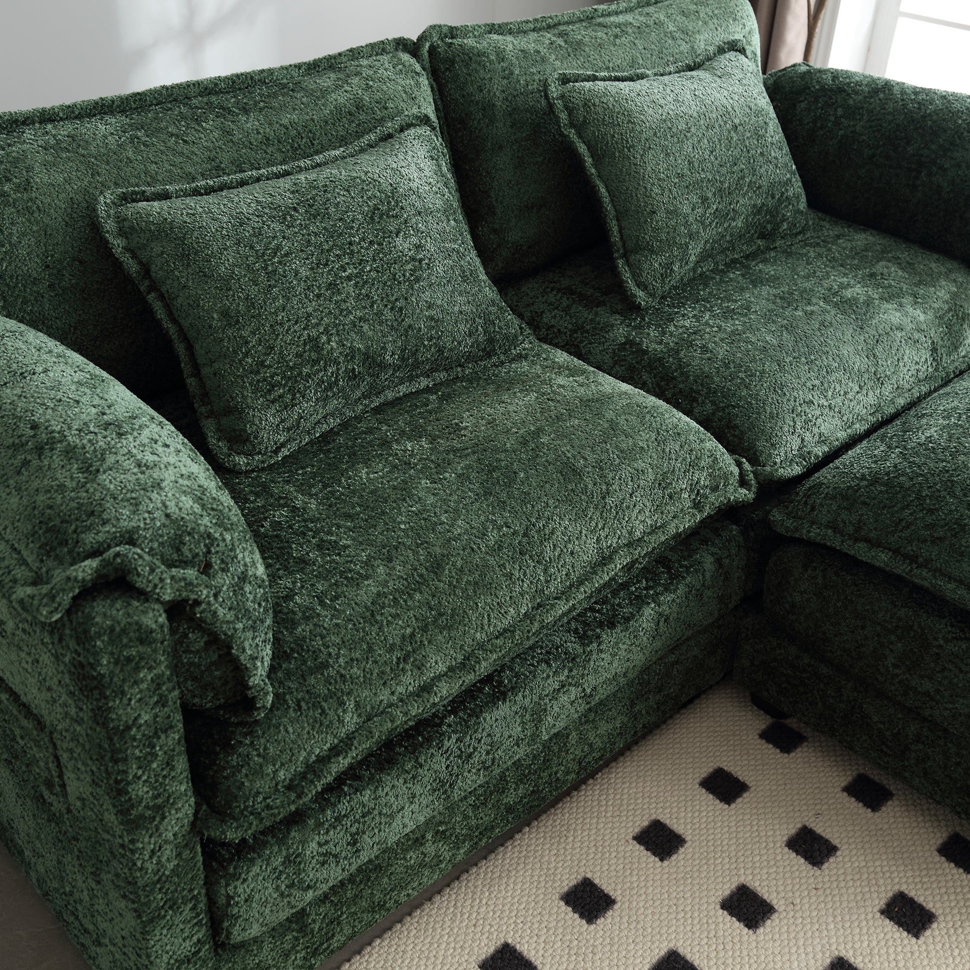 Plush dark green velvet sectional sofa with deep cushions and modern design