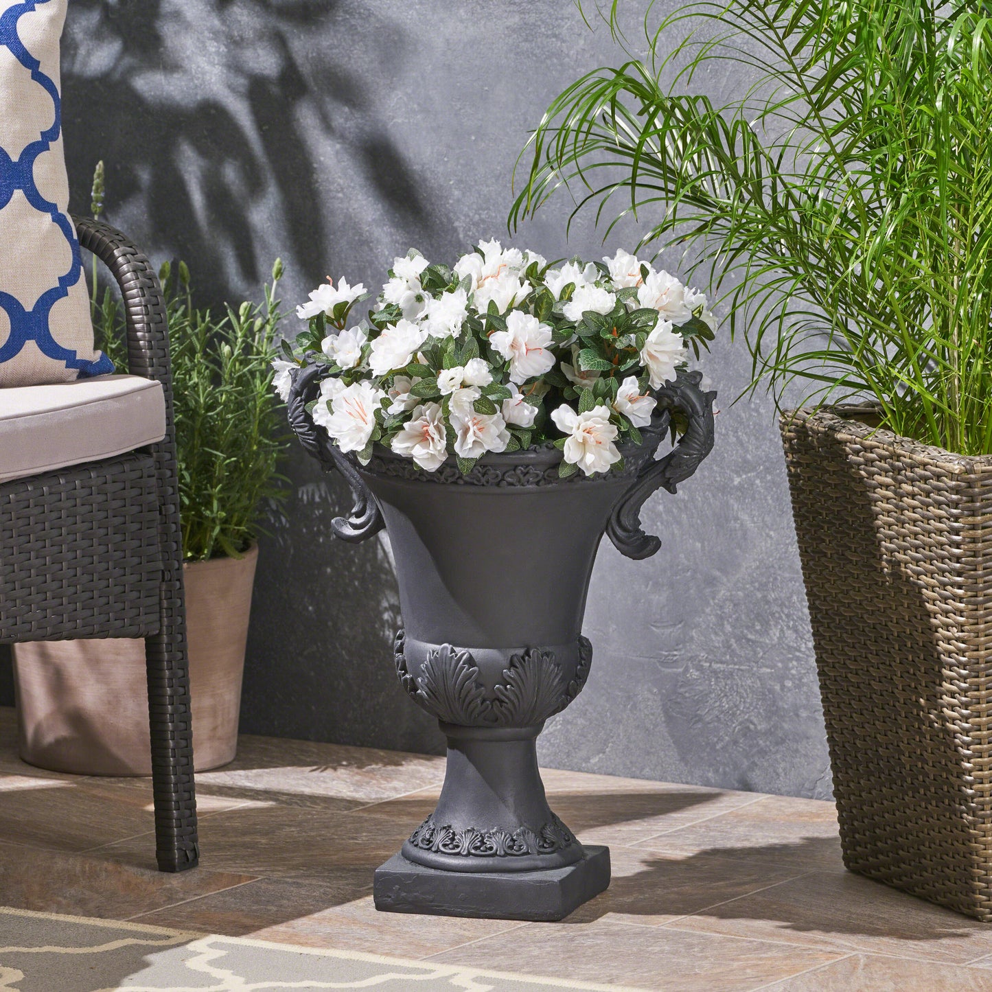 Antique gray urn planter with white azaleas and ornate handles perfect for garden decor