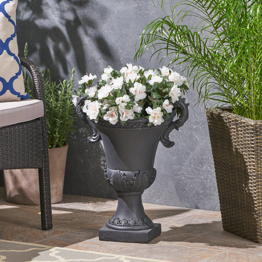Antique gray urn planter with white azaleas and ornate handles perfect for garden decor