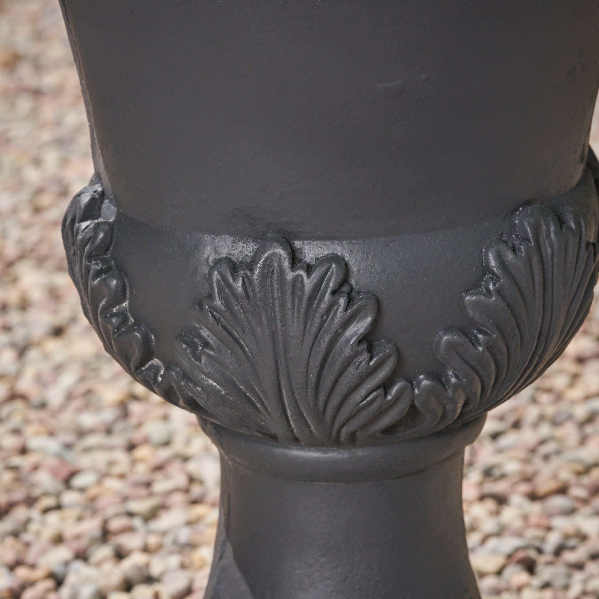 Dark gray cast iron urn with ornate acanthus leaf detailing