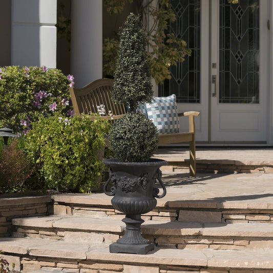 Elegant black urn with sculpted cherubs and roses featuring a conical topiary plant
