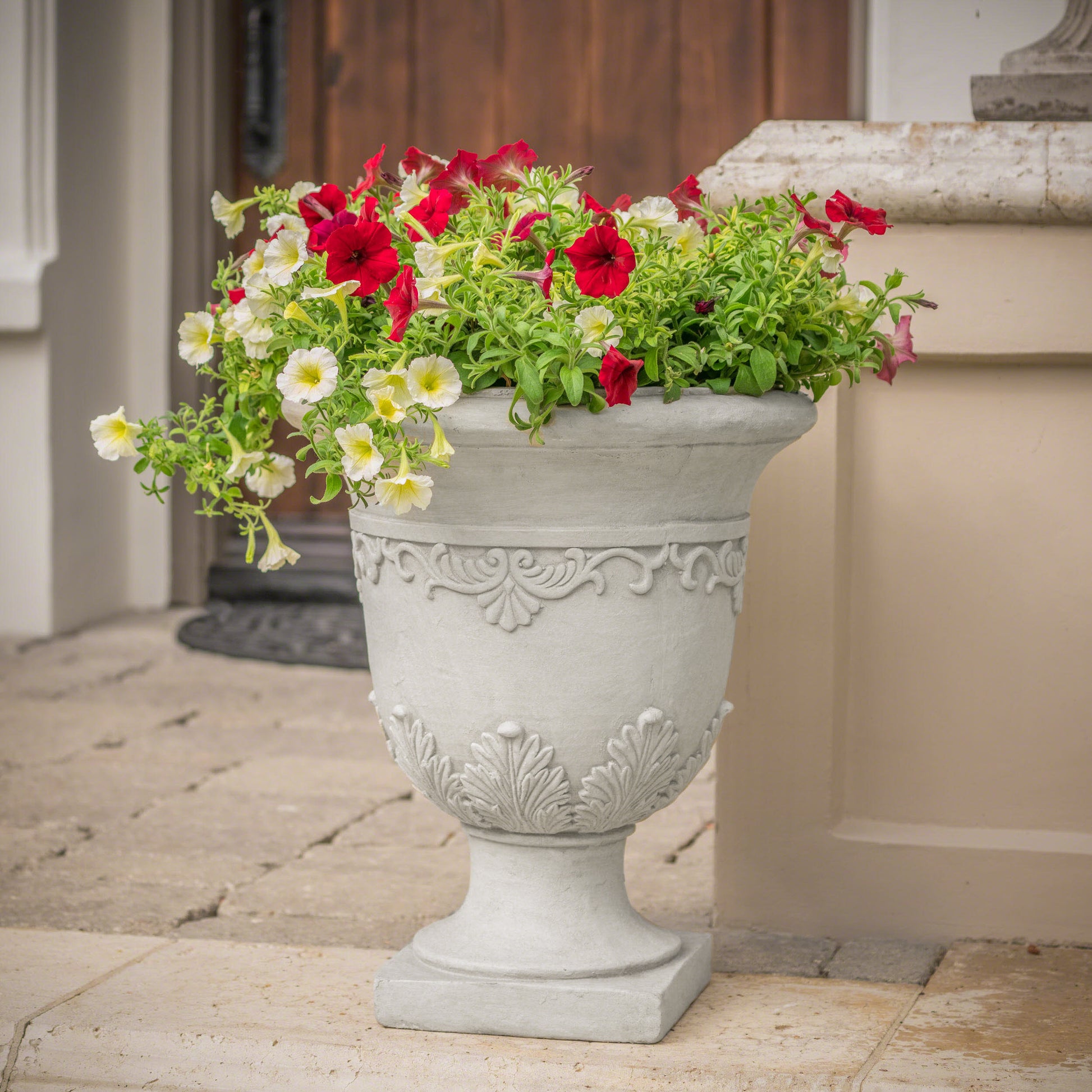 Gray decorative planter filled with red and yellow petunias