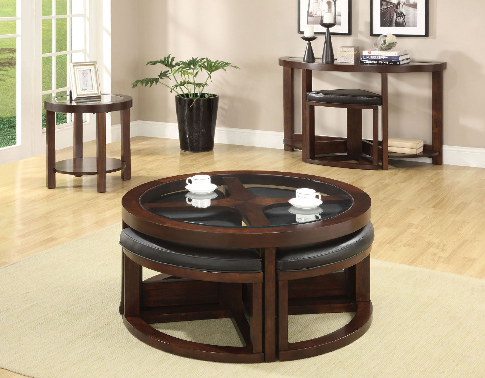 Round coffee table with glass top and four dark leather ottomans tucked underneath